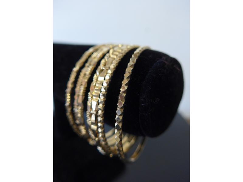 SEPT BRACELETS rigides en or jaune (750)...