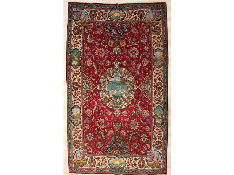 TAPIS en laine à décor à fond rouge de médaillons...