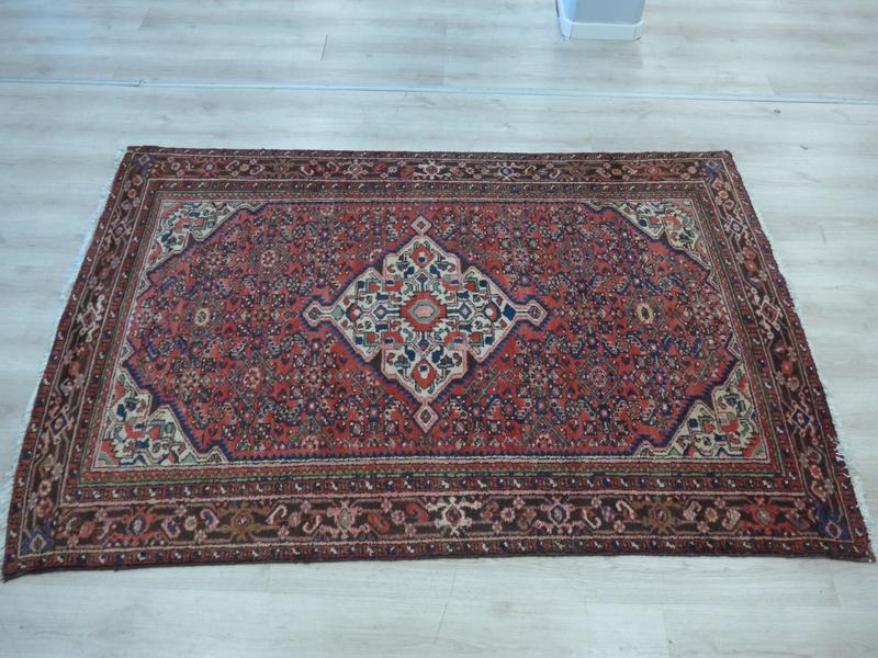 TAPIS en laine à décor d'un médaillon central...