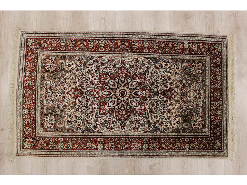 *TAPIS en laine à décor d'une rosace centrale...