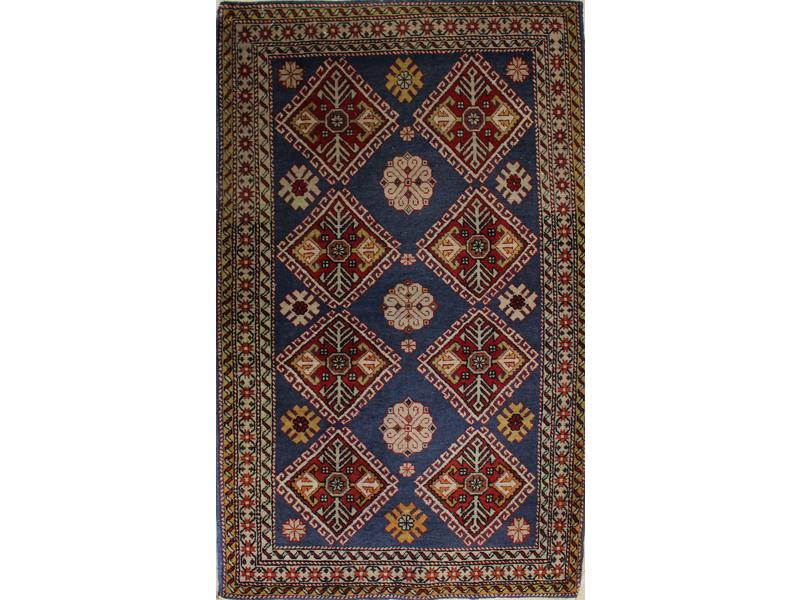 *PETIT TAPIS en laine à décor de huit losanges...