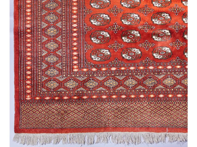 GRAND TAPIS en laine à fond rouge à décor...