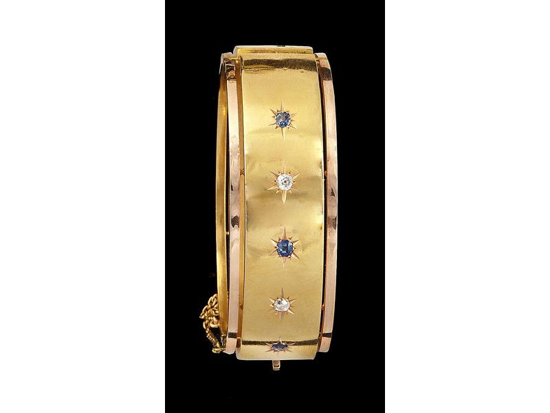 BRACELET rigide deux ors ouvrant avec chaîne...