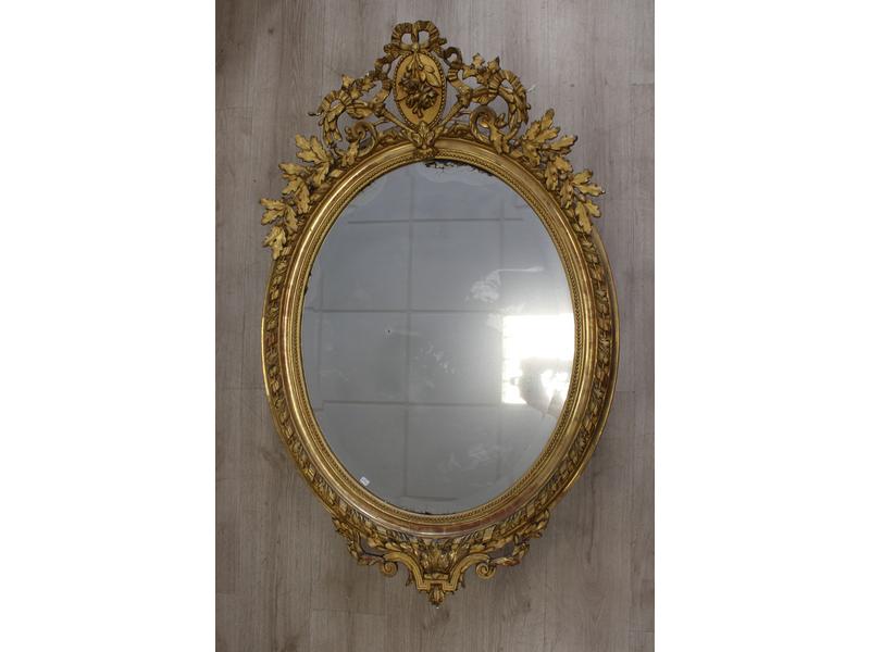MIROIR ovale en bois et stuc doré à fronton...