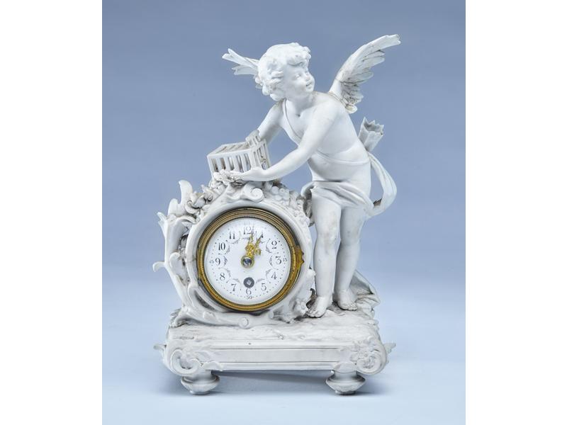 PETITE PENDULE en biscuit figurant l'Amour...