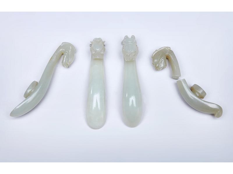 QUATRE FIBULES en jade sculpté à tête de...