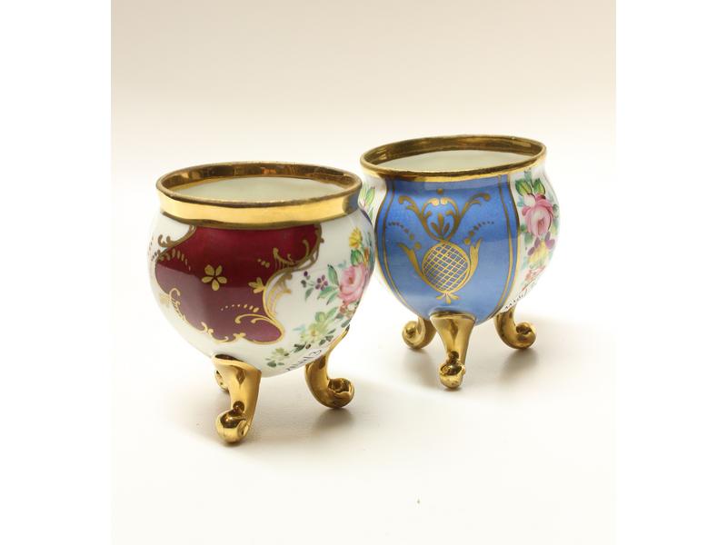 DEUX POTS sur trois pieds en porcelaine polychrome...