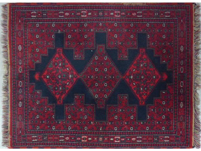 PETIT TAPIS EN LAINE à fond rouge à décor...