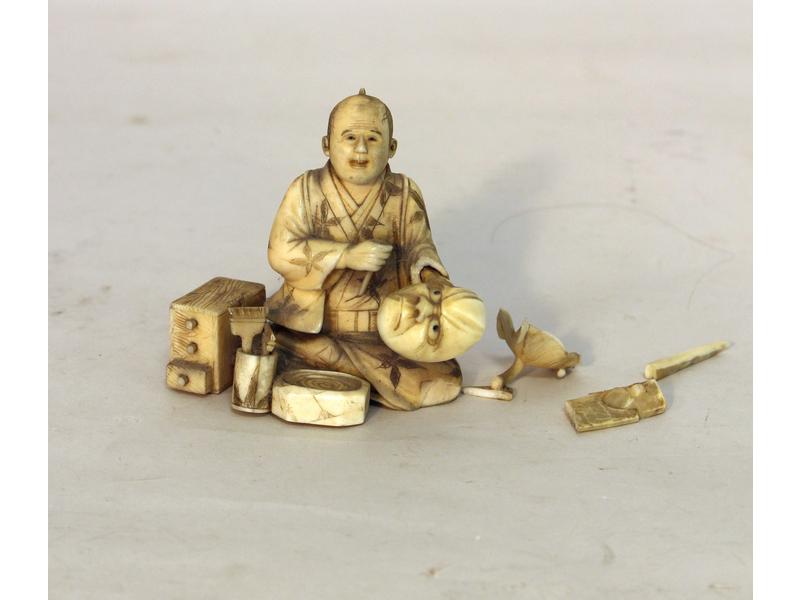 PETIT OKIMONO en ivoire représentant un sculpteur...