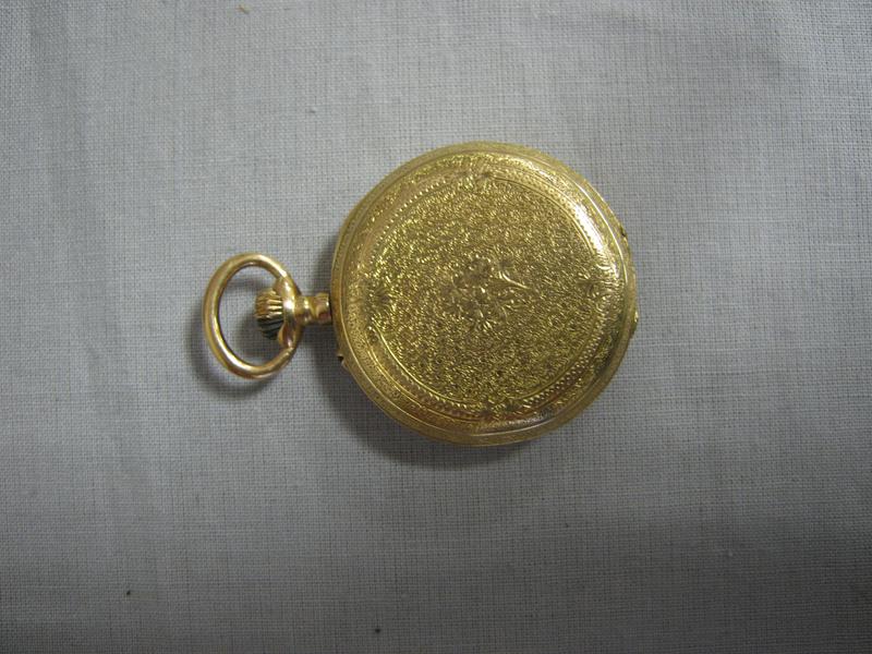 MONTRE de col en or jaune, à décor ciselé...