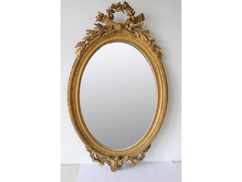 MIROIR ovale en bois et stuc doré à décor...