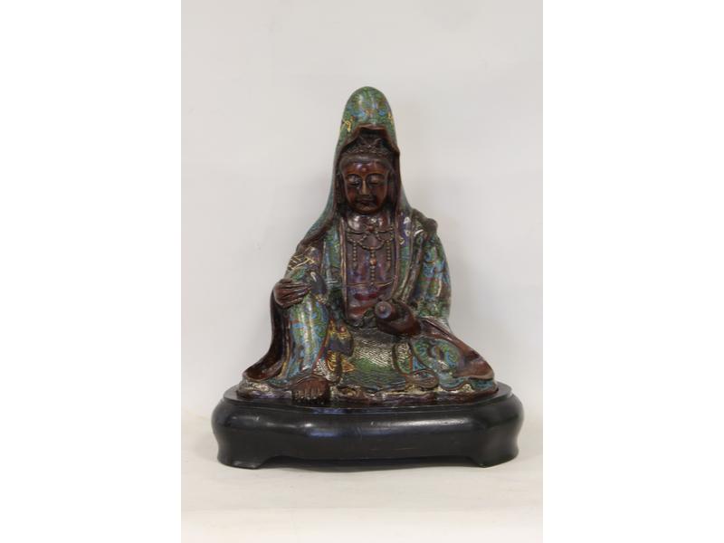 GUANYN assise un genou replié, tenant un...
