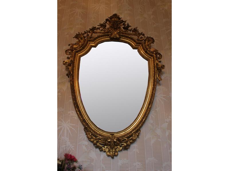 MIROIR de forme écusson en bois et stuc dorés...