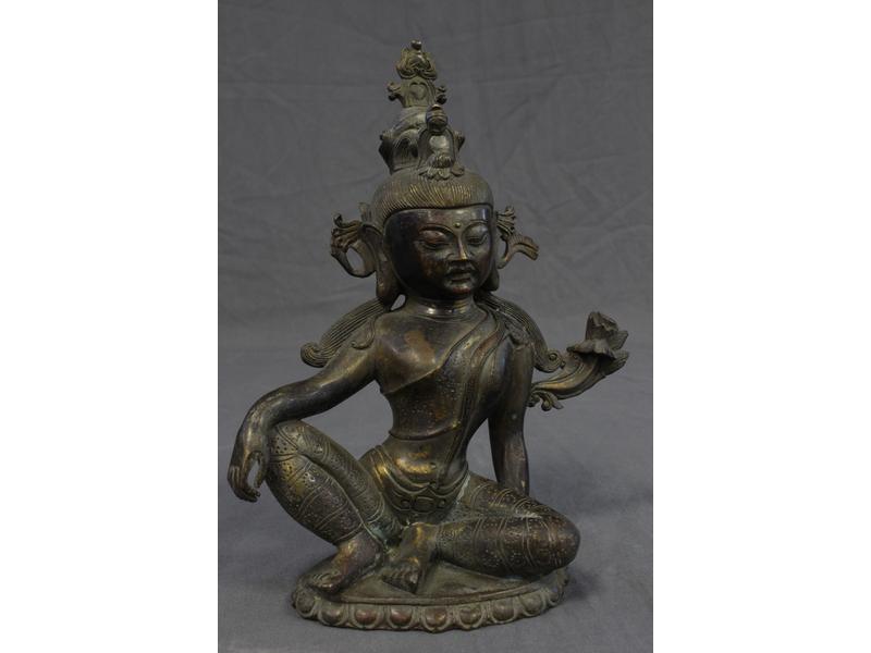 DIVINITE assise, un bras sur le genou, en...