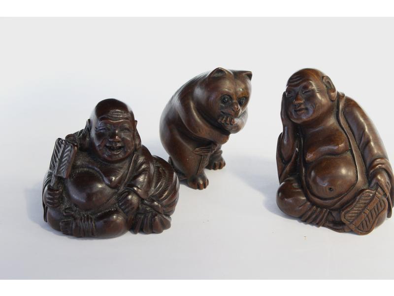 TROIS NETSUKES en bois exotique sculpté représentant...