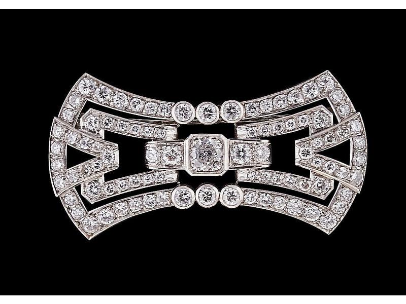 BROCHE stylisant un noeud en platine, sertie...