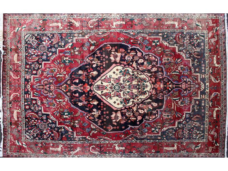 TAPIS en laine polychrome à décor d'un médaillon...