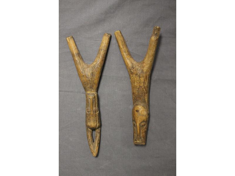 DEUX LANCE-PIERRES en bois sculpté de têtes...
