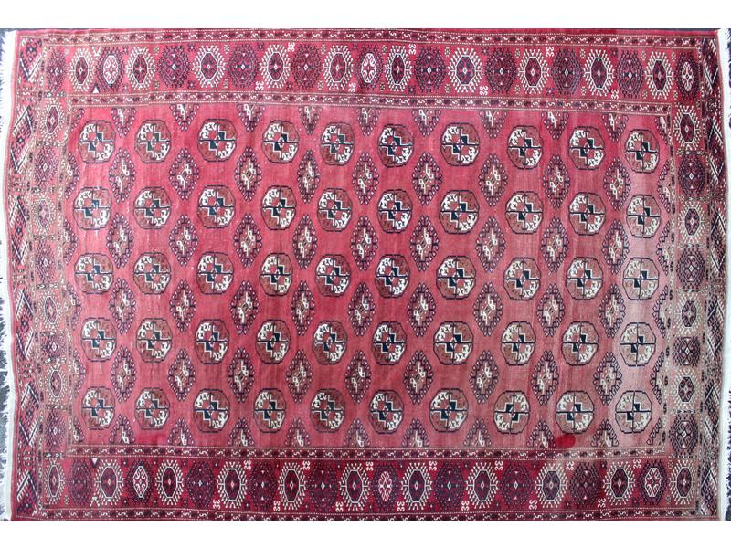 TAPIS en laine à fond rouge à décor de losanges...