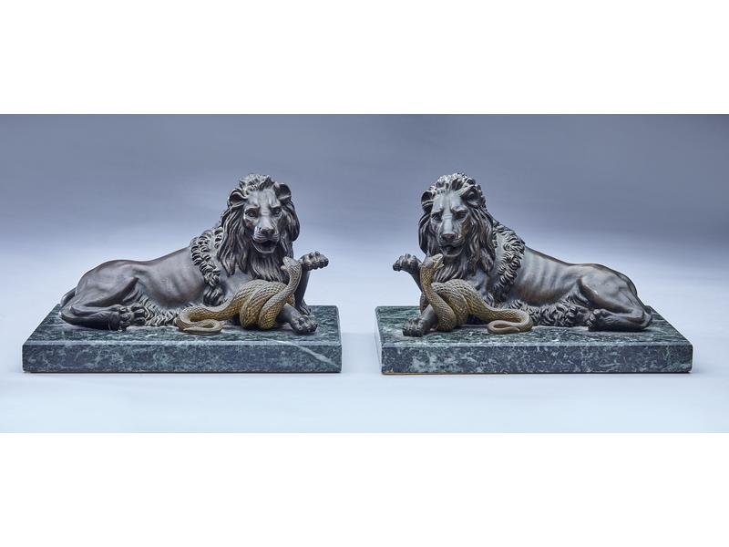 PAIRE DE LIONS ASSIS TERRASSANT UN SERPENT...