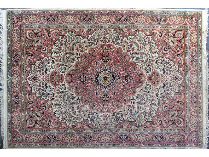 TAPIS en laine à décor de rinceaux et médaillon...