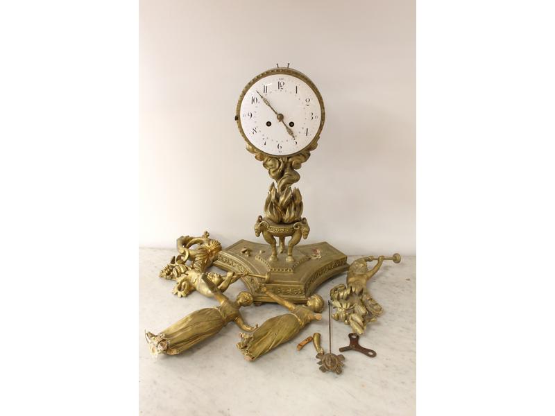 PENDULE en bois doré et sculpté à deux vestales...