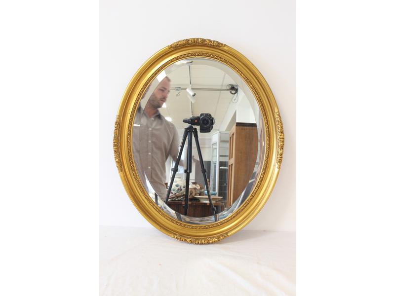 MIROIR OVALE en bois et stuc doré à décor...