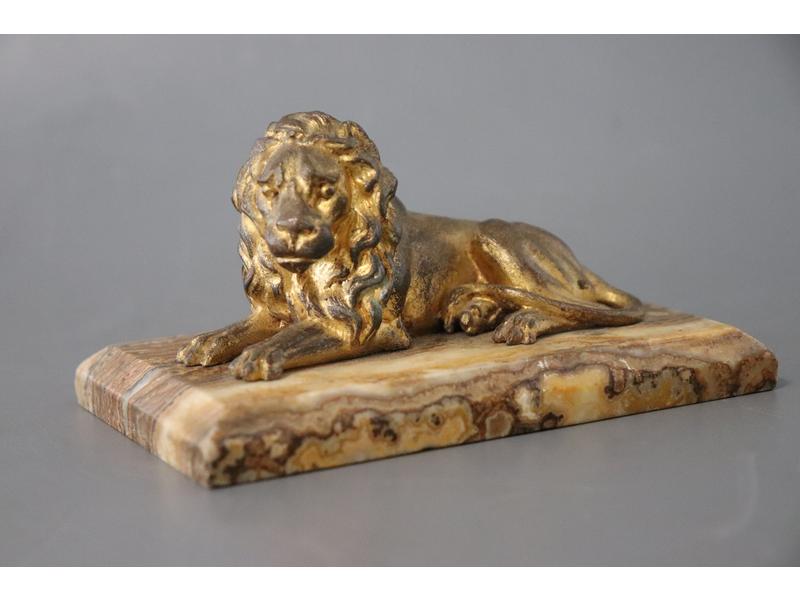 LION couché en bronze doré, sur un socle...