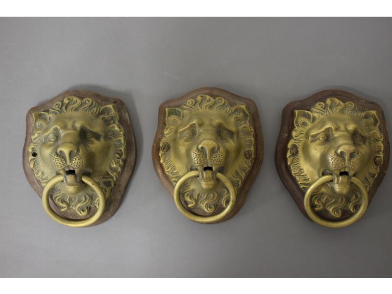 SUITE DE TROIS MUFLES DE LION retenant un...