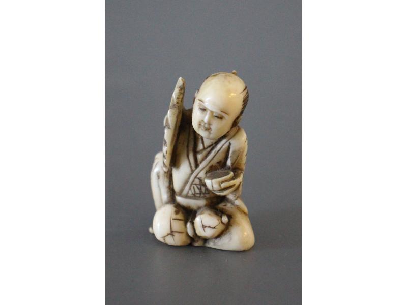 NETSUKE en ivoire à décor d'un personnage...