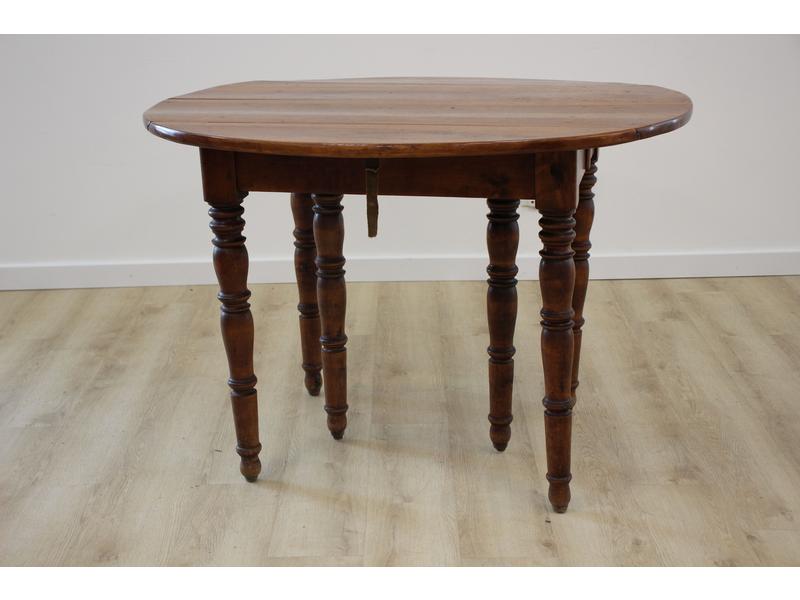 TABLE ronde à volets en noyer ciré, à deux...
