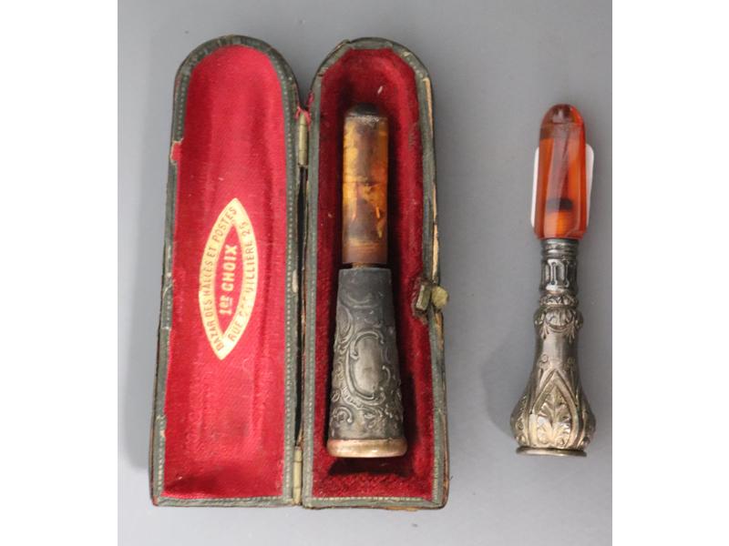 DEUX PORTE-CIGARETTES en ambre et argent...