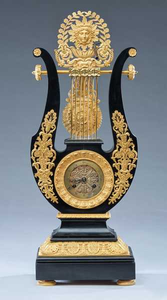 PENDULE LYRE en bois noirçi à riche ornementation...