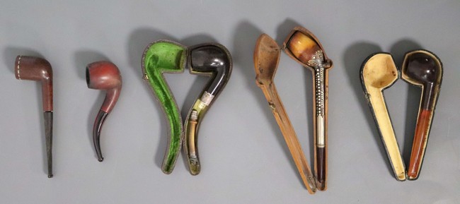 CINQ PIPES en bois sculpté et ambre, l'une...