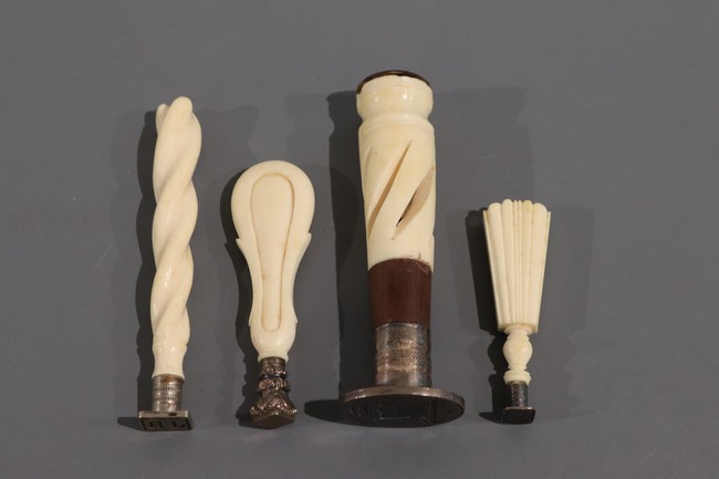 QUATRE CACHETS à fût en ivoire sculpté.