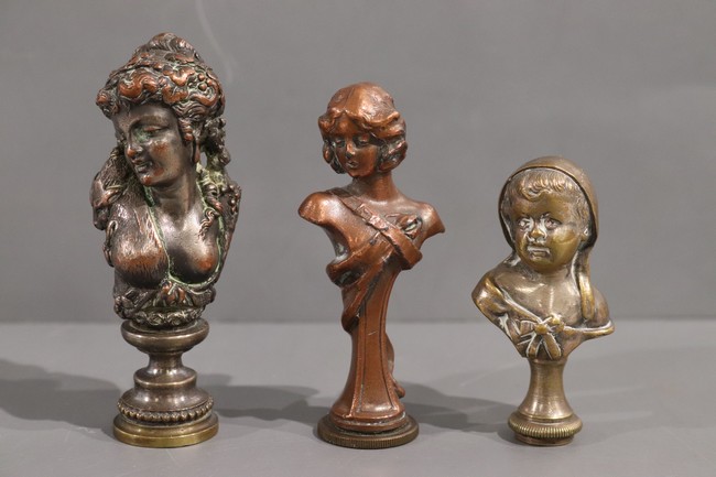 TROIS CACHETS en bronze à buste de femme...