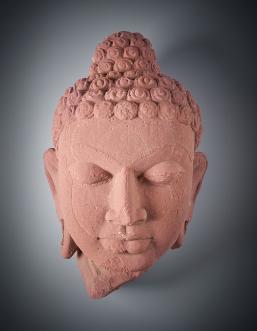 TÊTE DE BOUDDHA en grès rose sculpté dans...