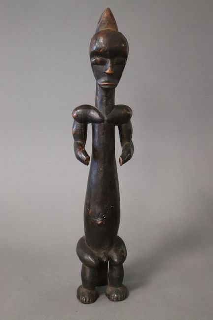 STATUETTE D'HOMME ASSIS à long corps en bois...