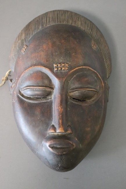 MASQUE en bois sculpté représentant un visage...