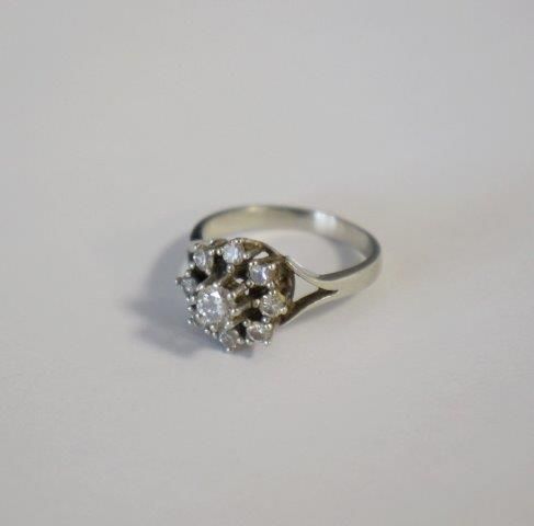 BAGUE "Fleurs" en or gris (750) centrée d'un...