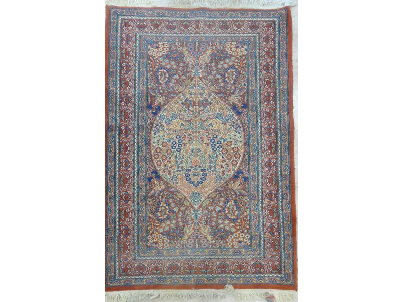 TAPIS en laine à fond rouge à décor de rinceaux...