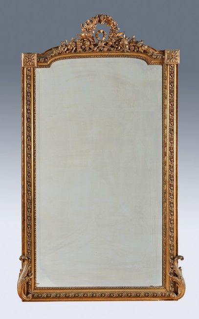 MIROIR en bois et stuc doré à fronton à décor...