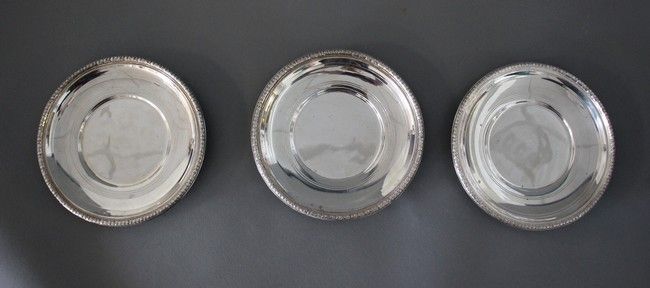 TROIS DESSOUS DE BOUTEILLE en argent à bordure...