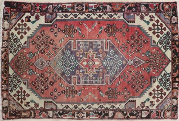 TAPIS en laine polychrome à décor d'un médaillon...