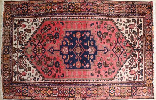 TAPIS en laine polychrome à décor d'un médaillon...