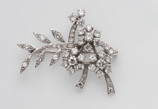 BROCHE en or gris (750) stylisant une branche...