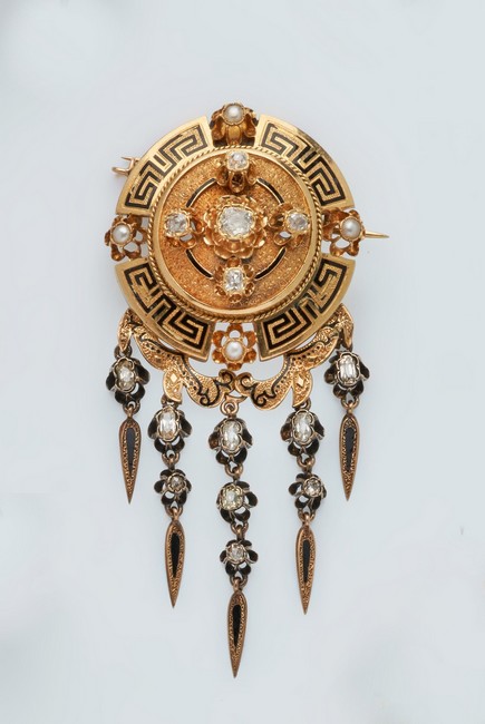 BROCHE ronde en or (750) à motif central...