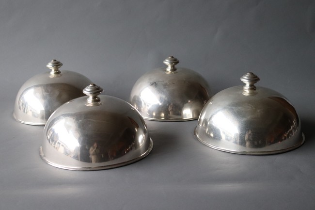 QUATRE CLOCHES à plat en métal argenté à...
