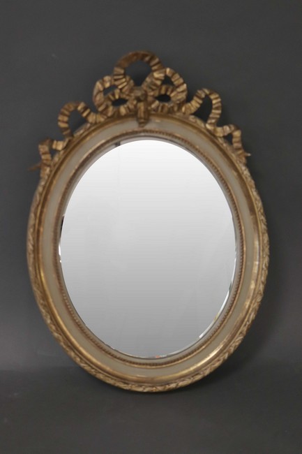 MIROIR ovale en bois doré sculpté à décor...
