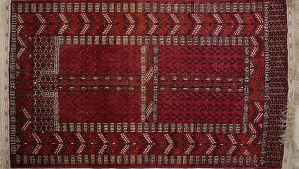 TAPIS en laine à fond rouge et décor de feuillage...